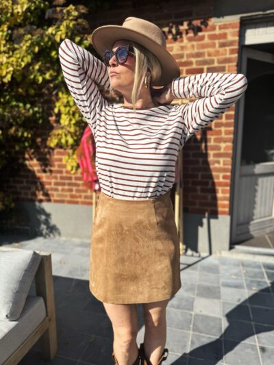 Femme blonde t-shirt rayé blanc et marron jupe daim camel chapeau camel lunettes de soleil